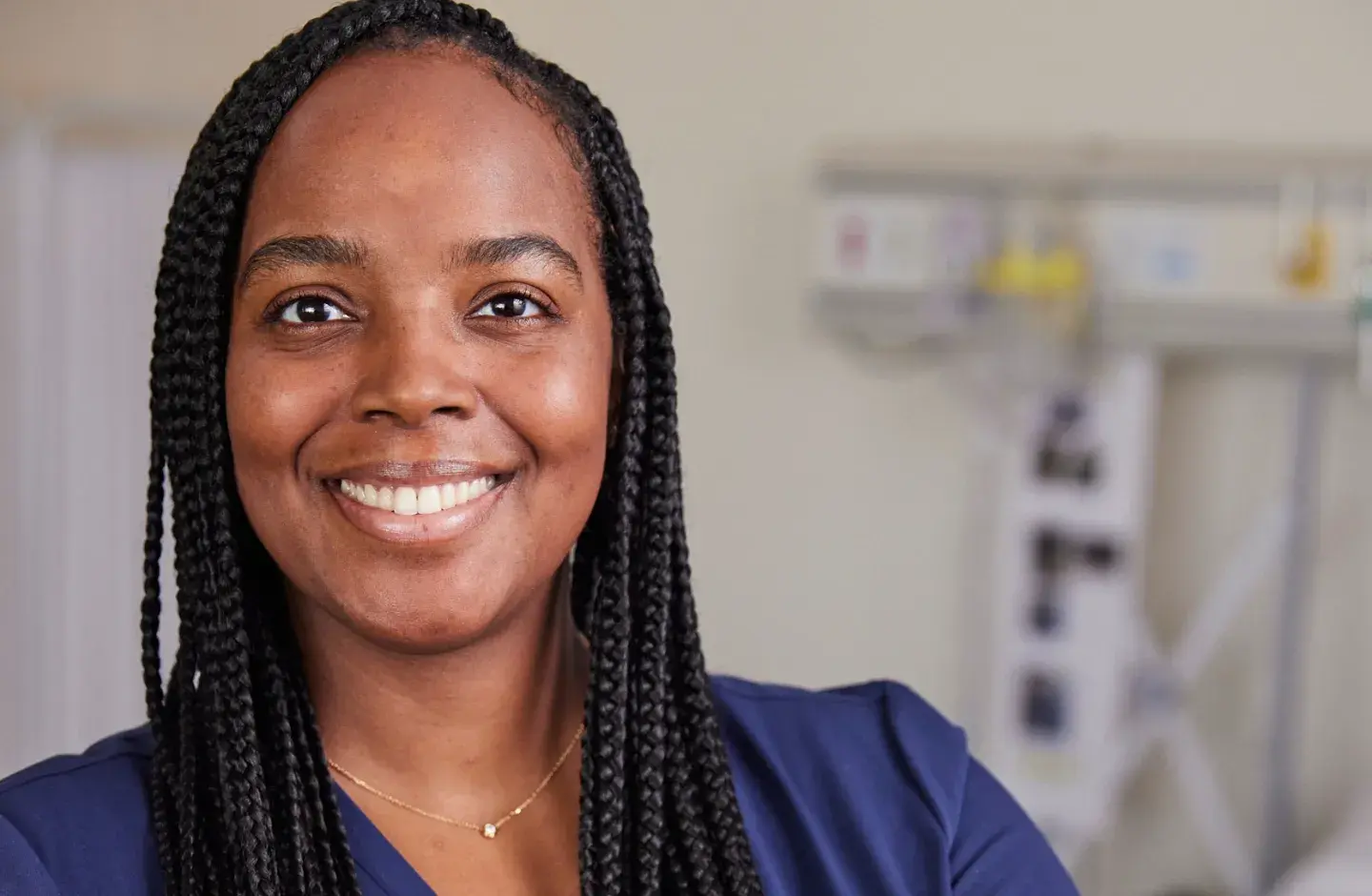 Nurse in a hospital room smiling and looking ahead
