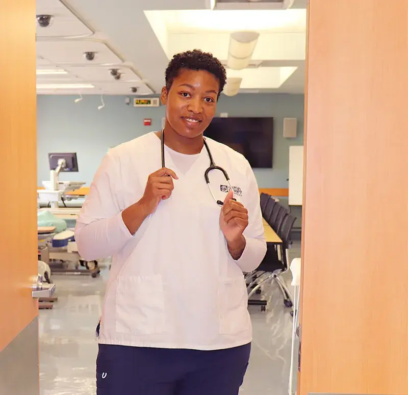 Nursing student stands in classroom doorway